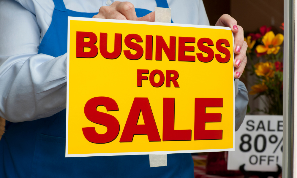 business owner putting up a sign selling your small business