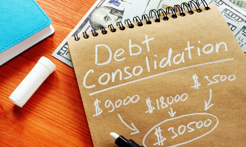 A notebook with some business debt consolidation calculations sits atop some cash.