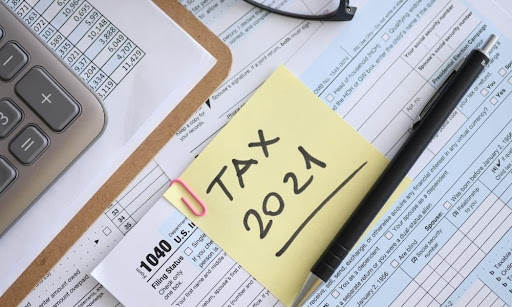 A desk holds a calculator and a taxpayer’s form 1040, where you can find the prior year AGI