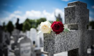 A red and white rose on top of a tombstone raises the question: Are funeral expenses tax-deductible?