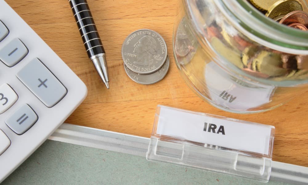 An Ira Folder Sits Next To A Calculator, A Pen, And Some Change, Signifying This Guide To Irs Form 5498.