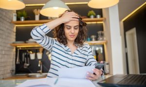 frustrated small business owner with her hand on her head