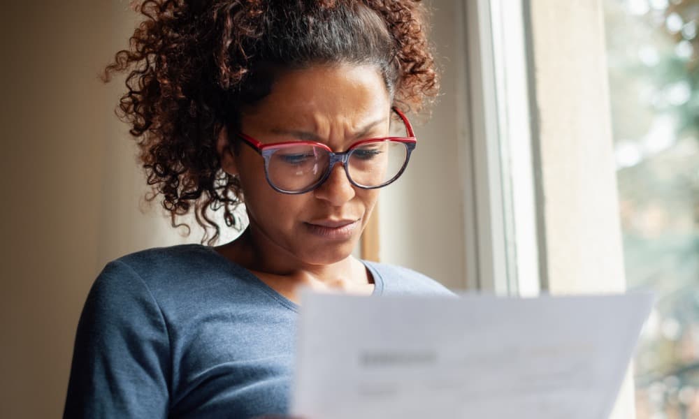 Concerned woman looking at IRS bank levy paperwork