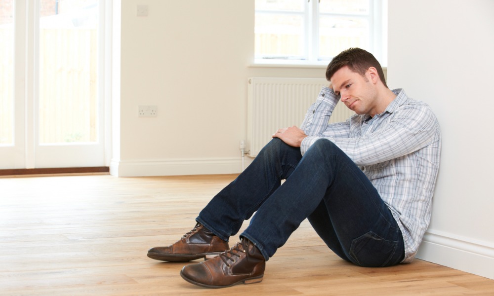 Sad man in empty house thinking about his IRS property seizure