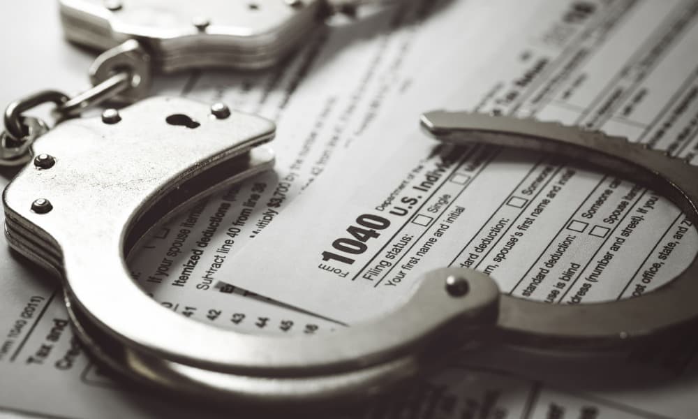 Can You Go To Jail For Not Filing Taxes? Handcuffs Sitting On Top Of A 1040 Tax Form Indicate Yes.