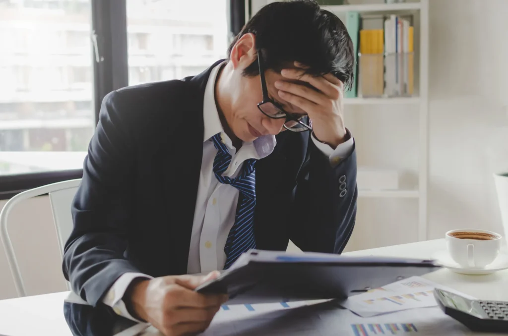 Stressed man looking over papers.