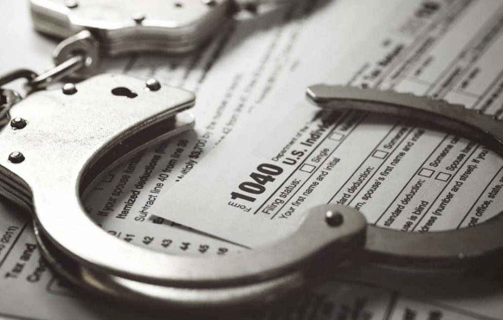 Can You Go To Jail For Not Filing Taxes? Handcuffs Sitting On Top Of A 1040 Tax Form Indicate Yes.