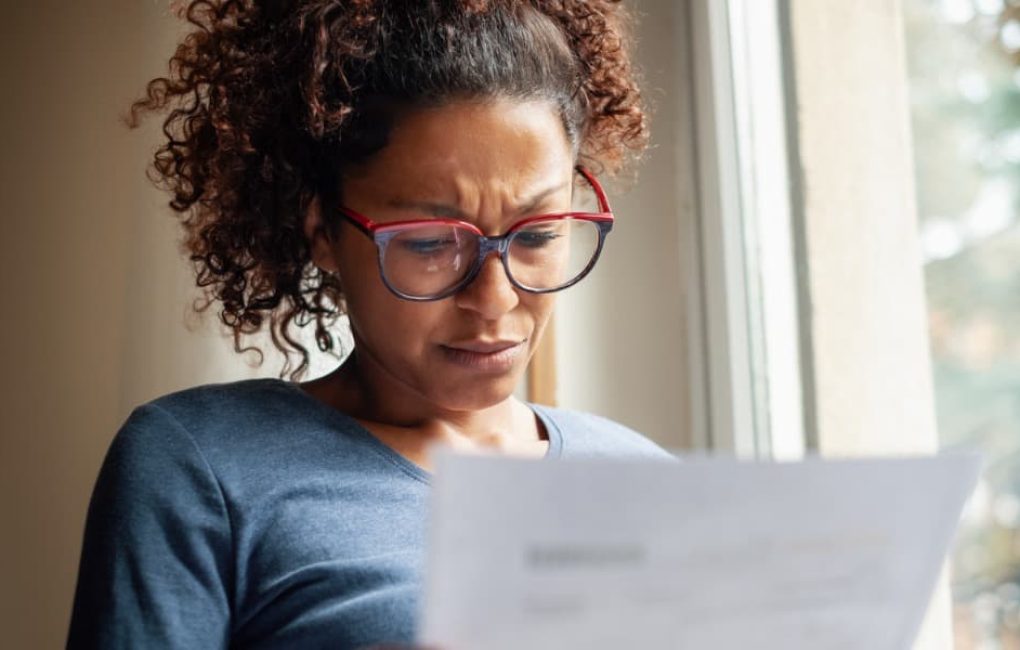Concerned Woman Looking At Irs Bank Levy Paperwork
