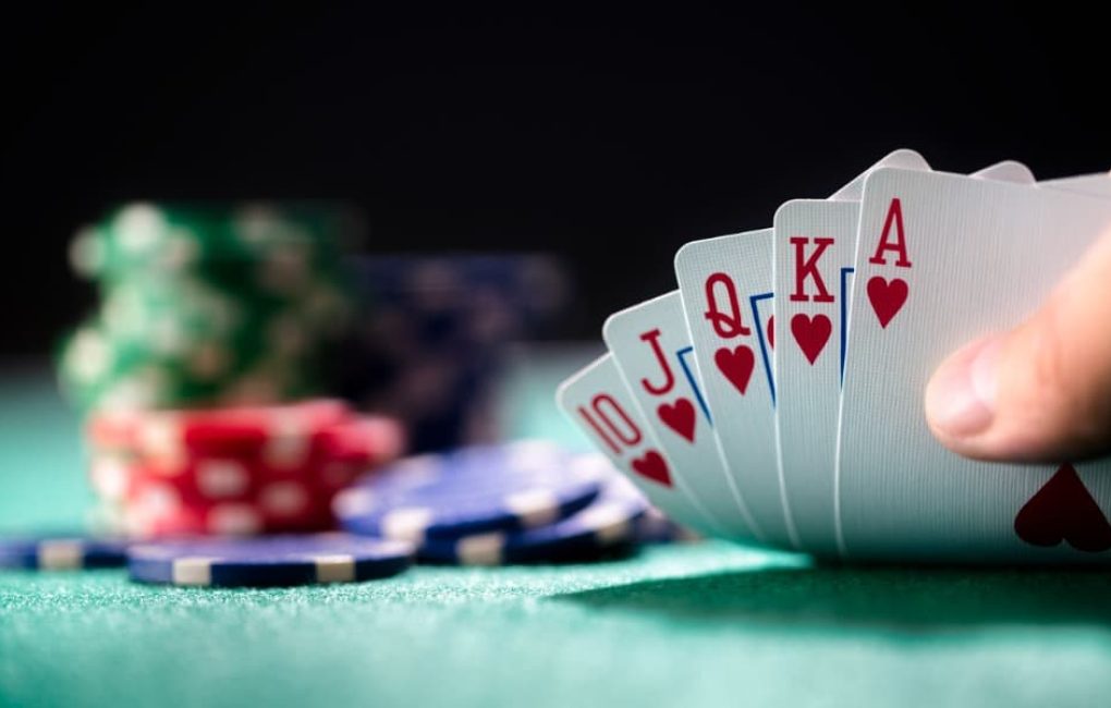 Poker Chips And A Hand Of Cards Showing A Royal Flush Being Played By A Pro Gambler Or An Amateur Gambler