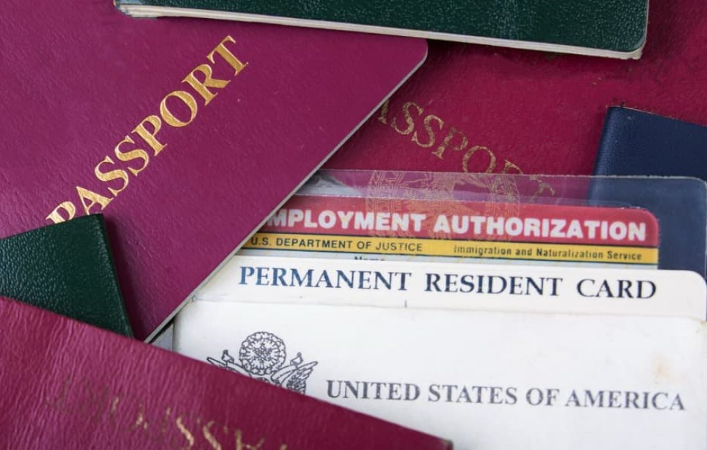 A Stack Of Passports And A U.s. Permanent Resident Card, Representing Foreign Asset Reporting