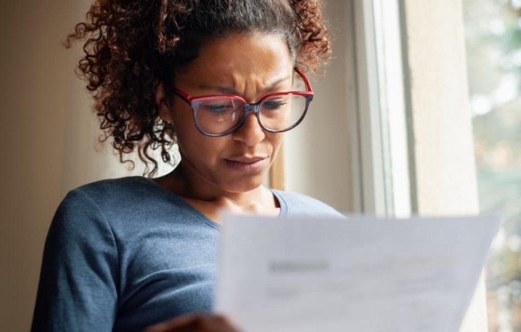 Frustrated Woman Looking At A Tax Document